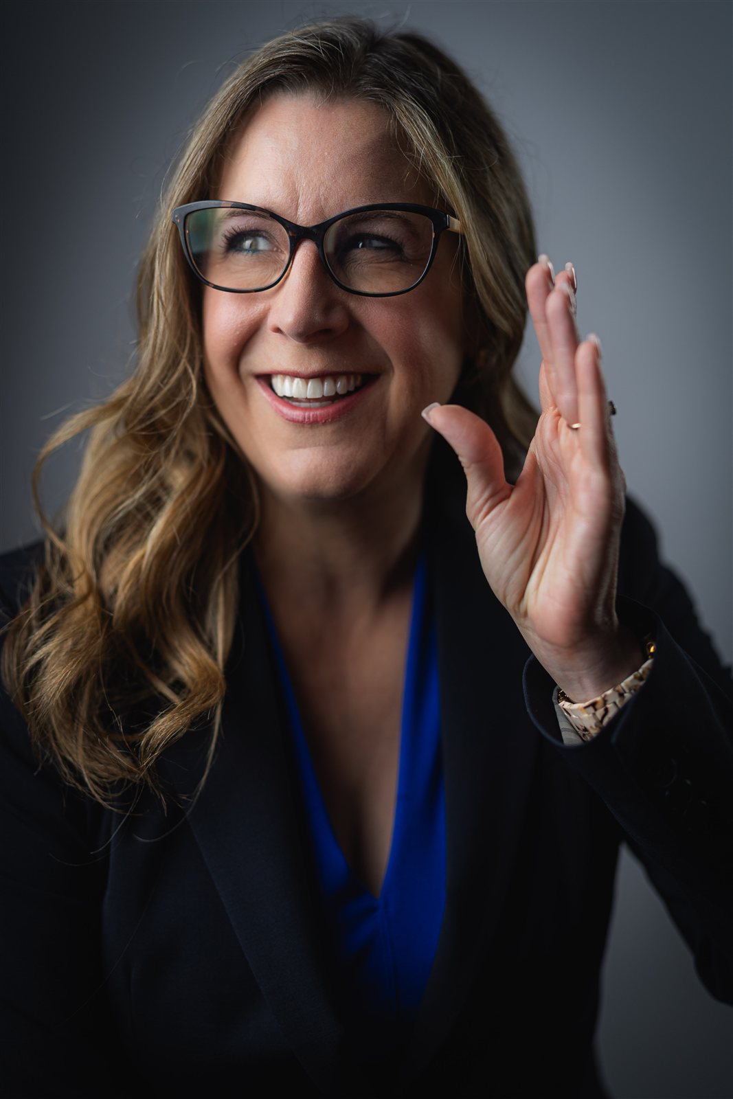Jennifer Davis laughing mid-conversation with a hand raised